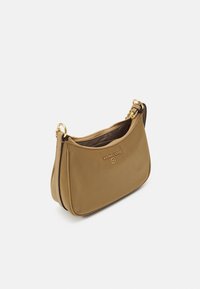 Tan læder crossbody taske med lynlås, guldfarvet hardware og prægede logo. Rund form med en glat tekstur og blød finish.