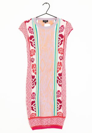 Vestido sin mangas de punto con patrones florales y geométricos en rosa y rojo, rayas verticales en turquesa y amarillo, colgado en una percha negra.