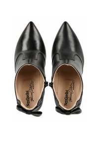 Chaussures noires en cuir à bout pointu avec un design scallopé, fermeture éclair intérieure et accents de nœud à l'arrière. L'intérieur présente un revêtement beige et un logo.