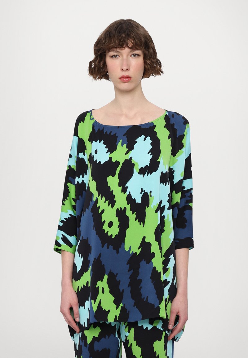 Long-sleeve top in vibrant green, blue, and black abstract pattern. Soft material, wide neckline, and loose fit, paired with matching bottom.