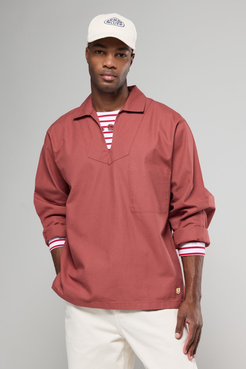 Roestkleurig long-sleeve shirt met een v-hals, een borstzak en manchet mouwen, gelaagd over een rood-wit gestreepte basis.