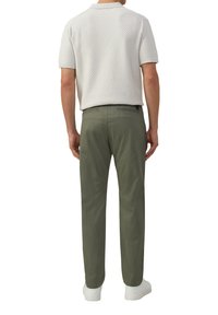 Hellgrau strukturiertes Poloshirt und olivgrüne Hose, mit schlanker Passform, kurzen Ärmeln und weißen Sneakers.