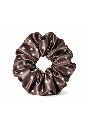 Brauner Satin-Scrunchie mit weißen Polka-Dots und einem kleinen Etikett mit der Aufschrift "le silque" auf weißem Hintergrund.