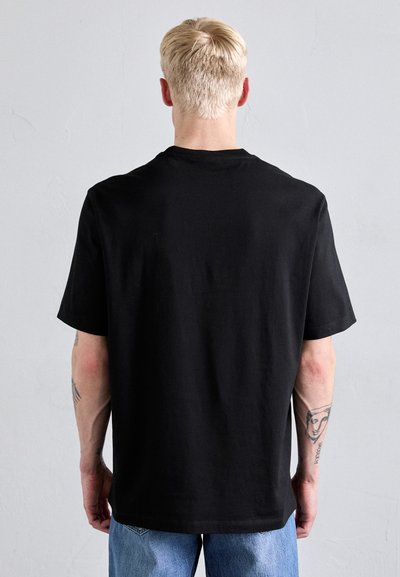 T-shirt en coton noir avec une coupe décontractée, des manches courtes et un col rond. Design uni, sans motifs ni accents visibles.