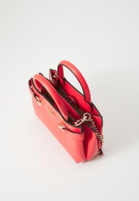 Red leather handbag with double handles, black edges, gold hardware, and a chain strap on a white background.