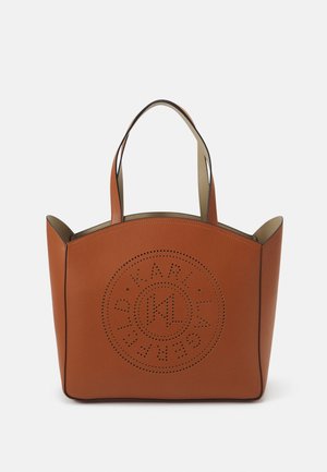 Bruine leren trolleytas met twee handvatten en een geperforeerd circulair logodesign aan de voorkant tegen een effen achtergrond.