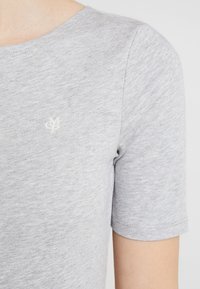 Grå kortærmet t-shirt lavet af blødt stof med en lille broderet logo på brystet. Rund halsudskæring og en afslappet pasform.