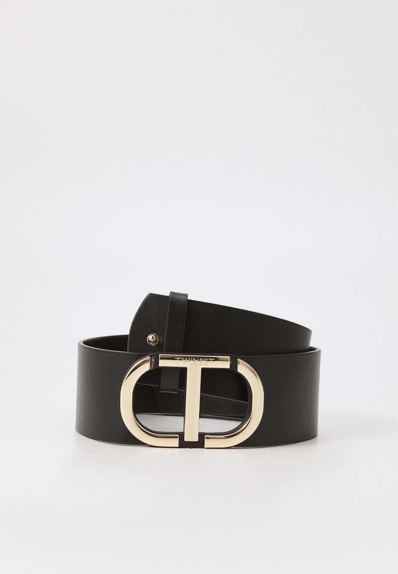 Black leather belt with a wide design, featuring a gold circular buckle with a "T" motif and embossed brand name. Smooth texture.
