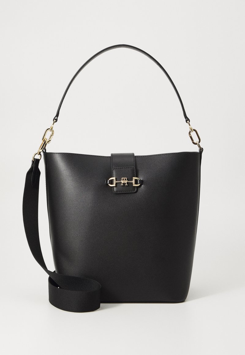 Černá kožená kabelka se strukturovaným tvarem, zlatými kovovými detaily, plochými uchy a odnímatelným textilním popruhem pro univerzálnost.