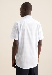 Camicia a maniche corte, azzurro chiaro e bianco a quadri, con orlo curvo e colletto dritto, realizzata in tessuto leggero.