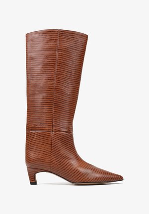 Brązowy skórzany botek do kolan z teksturowanym wzorem, spiczastym noskiem i niskim, ukośnie ściętym obcasem. Gładkie wykończenie z delikatnym połyskiem.