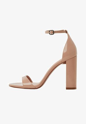 Sandale à talon haut en cuir verni nude avec une bride de cheville et un talon bloc, design ouvert à l'avant.