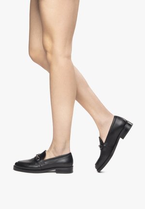 Mocassini in pelle nera con tacco basso, presentano cuciture sottili e un elegante dettaglio con fibbia. Texture liscia e forma classica.
