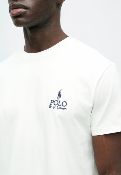 Λευκό βαμβακερό μπλουζάκι με κεντητό λογότυπο σε ναυτικό μπλε χρώμα ενός παίκτη πόλο και κείμενο "POLO Ralph Lauren" στο αριστερό στήθος, στρογγυλή λαιμόκοψη.