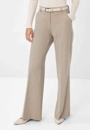 Beige weite Hosen mit glatter Textur, ausgestattet mit Gürtelschlaufen und einem passenden hellen Gürtel. Abgerundet mit spitzen Absatzschuhen.
