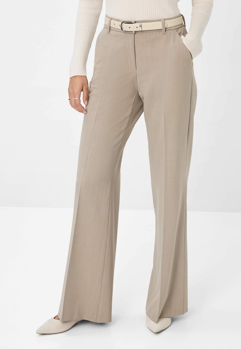 Pantalons beige à jambes larges avec une texture lisse, dotés de passants de ceinture et d'une ceinture assortie de couleur claire. Complétés par des escarpins à bout pointu.