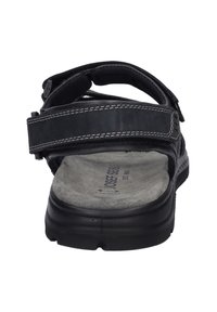 Sandali neri con cinturini regolabili, una soletta grigia imbottita e una suola in gomma resistente. Accenti di cuciture bianche ben visibili.