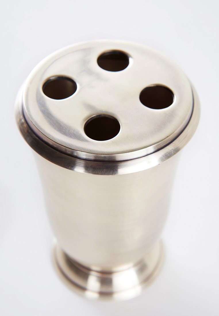 Metalcocktailshaker med en polerad silverfinish, rund form och ett kupolformat lock med fyra cirkulära hål.