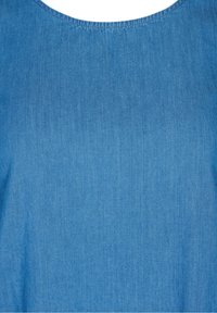 Top de denim de color azul claro con escote redondeado, textura suave y detalles de costura sutiles. La tela parece lisa y ligeramente deslavada.