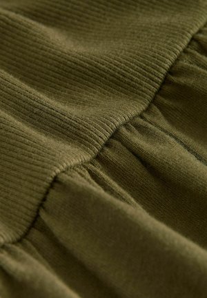 Olive green fabric featuring a ribbed top section and gathered lower portion, showcasing a soft texture and smooth finish.