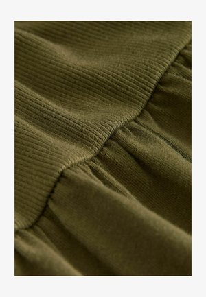 Olive green fabric featuring a ribbed top section and gathered lower portion, showcasing a soft texture and smooth finish.