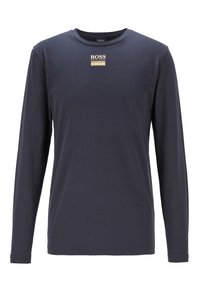 Langärmliges, navyblaues Baumwoll-T-Shirt mit rundem Halsausschnitt. Mit einem kleinen goldenen Logo auf der Brust. Glatte Textur mit figurnaher Passform.