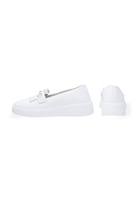Witte instapschoenen met een gladde textielen bovenkant, voorzien van een decoratieve franjerand en een witte rubberen zool met een gestructureerde afwerking.
