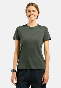 T-shirt à manches courtes vert olive avec un col rond et une texture lisse, présentant un logo discret sur le côté supérieur gauche.