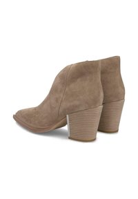 Par de botines de ante marrón con tacones apilados y punta afilada, colocados espalda con espalda sobre un fondo blanco.