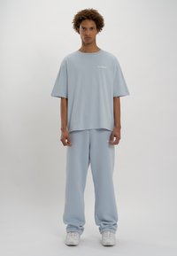 LOW LIGHTS STUDIOS® BASIC LOGO JOGGER - Pantalones deportivos - sky blue
