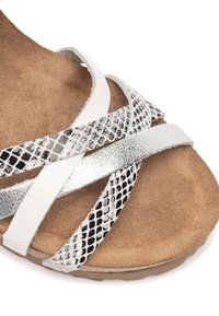 Cross-strap sandaal met zilveren en gestructureerde slangprint banden, zachte bruine suede voetbed en een slipvaste zool.