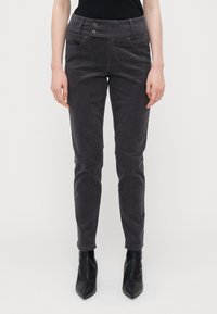 Grå cordskjorter med slim fit, med dobbeltknapp i midjen, frontlommer og en myk tekstur. Kombinert med svarte ankelstøvler.