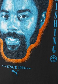 Sort stof med et grafisk design, der har et blåt og orange halftone-portræt og teksten "UDGIVELSE SIDEN 1973" i blåt.