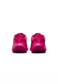 Zapatillas de correr impermeables rosas con suelas texturizadas, que presentan un talón ligeramente elevado, una etiqueta de tirón y la marca "GORE-TEX" en el lateral.