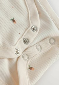 Baumwoll-Bodysuit mit weichem Rippstrick, in Off-White, mit einem kleinen Eichelprint und silbernen Druckknöpfen entlang des unteren Randes.