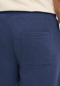 Tamsiai mėlyni medvilnės mišinio šortai su tekstūruota apdaila, turi stačiakampę kišenę gale ir elastingą juosmenį patogumui.