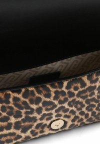 Tasche aus Kunstleder mit Leopardenmuster, glänzend schwarzem Deckel, goldfarbenen Beschlägen und innen mit Musterfutter. Verfügt über einen magnetischen Druckknopfverschluss.