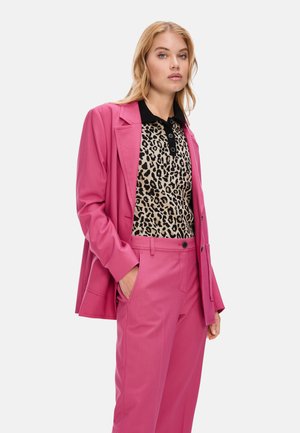 Pink tailored blazer over a leopard print polo shirt with black collar, paired with matching pink trousers. Smooth fabric and structured design.