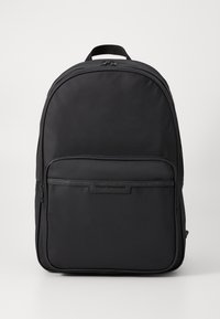 Black nylon backpack featuring a rounded shape, front zippered pocket, and a logo plaque. Smooth texture with padded shoulder straps.
