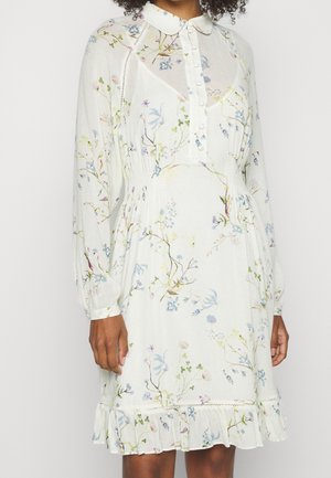 Kleid mit Blumenmuster aus leichtem, luftigen Stoff, langen Ärmeln, einem Hemdkragen und einem Rüschensaum, überwiegend in Weiß mit Pastellfarben.