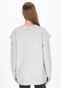 Szara dziergana sweter z miękkim, teksturowanym wykończeniem; ma krótkie rękawy, okrągły dekolt i nieco dłuższy tylny dół.