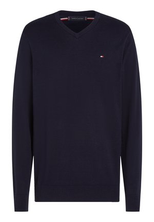 Temno modra jopica z v-izrezom in rebrastimi manšetami ter spodnjim robom. Iz mehke pletene tkanine, z majhnim logotipom na prsnem delu.