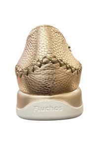 Zapato de cuero metálico dorado con un acabado texturizado, que presenta costuras decorativas y una suela de goma blanca con una marca emblematizada.