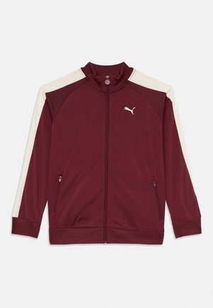 Bordowa kurtka zapinana na zamek z kremowymi akcentami, wysoki kołnierz, boczne kieszenie i ściągacze na mankietach. Posiada logo Puma na lewej piersi. Gładka faktura materiału.