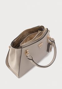 Sac à main synthétique beige à la forme structurée, orné de ferrures dorées et de bords noirs contrastants. Comprend plusieurs compartiments et une étiquette amovible.