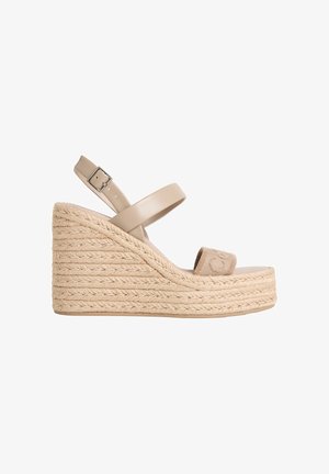 Beige Keilsandalette mit geflochtener Seilsohle, verstellbarem Knöchelriemen mit Schnalle und Stoffzehenriemen mit dezentem Logodetail.