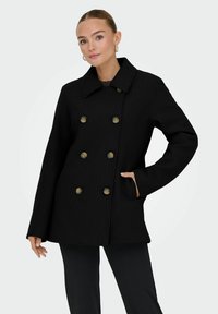 Mustasta tuplakaarisesta takista, jossa on leveä kaulus, suuret kultas�ävyiset napit, sivutaskut ja muotoiltu istuvuus. Pehmeä villamainen rakenne.