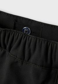 Črn pas iz tkanine z nabranimi teksturami, ki vsebuje zapiranje z modrim gumbom in elastiko za prilagodljivo prileganje. Gladek in trpežen material.