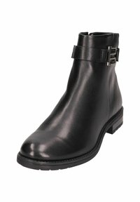 Bottine noire en cuir avec une finition lisse, fermeture éclair sur le côté et une sangle décorative avec une boucle en métal argenté. Talon carré bas.