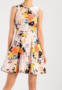 Pink sleeveless dress with a keyhole neckline, flared skirt, and a colorful floral pattern in shades of orange, yellow, black, and blue.